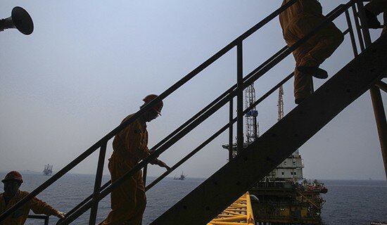 Employees walk up a staircase in the production area at the Mexico's state-run oil monopoly Pemex platform "Ku Maloob Zaap" in the Northeast Marine Region of Pemex Exploration and Production in the Bay of Campeche